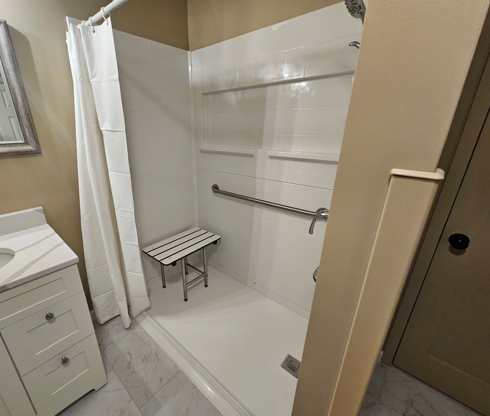 A bathroom with a walk in shower and a bench