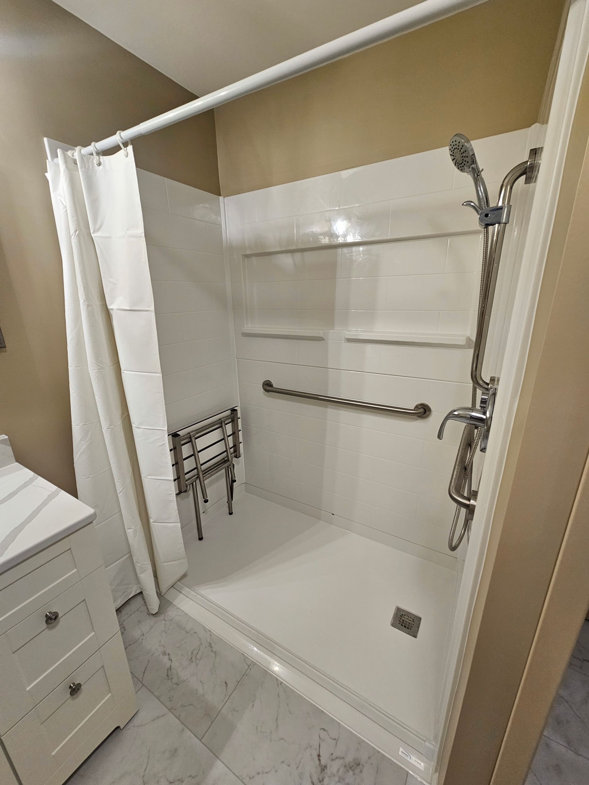 A bathroom with a walk in shower and a sink.
