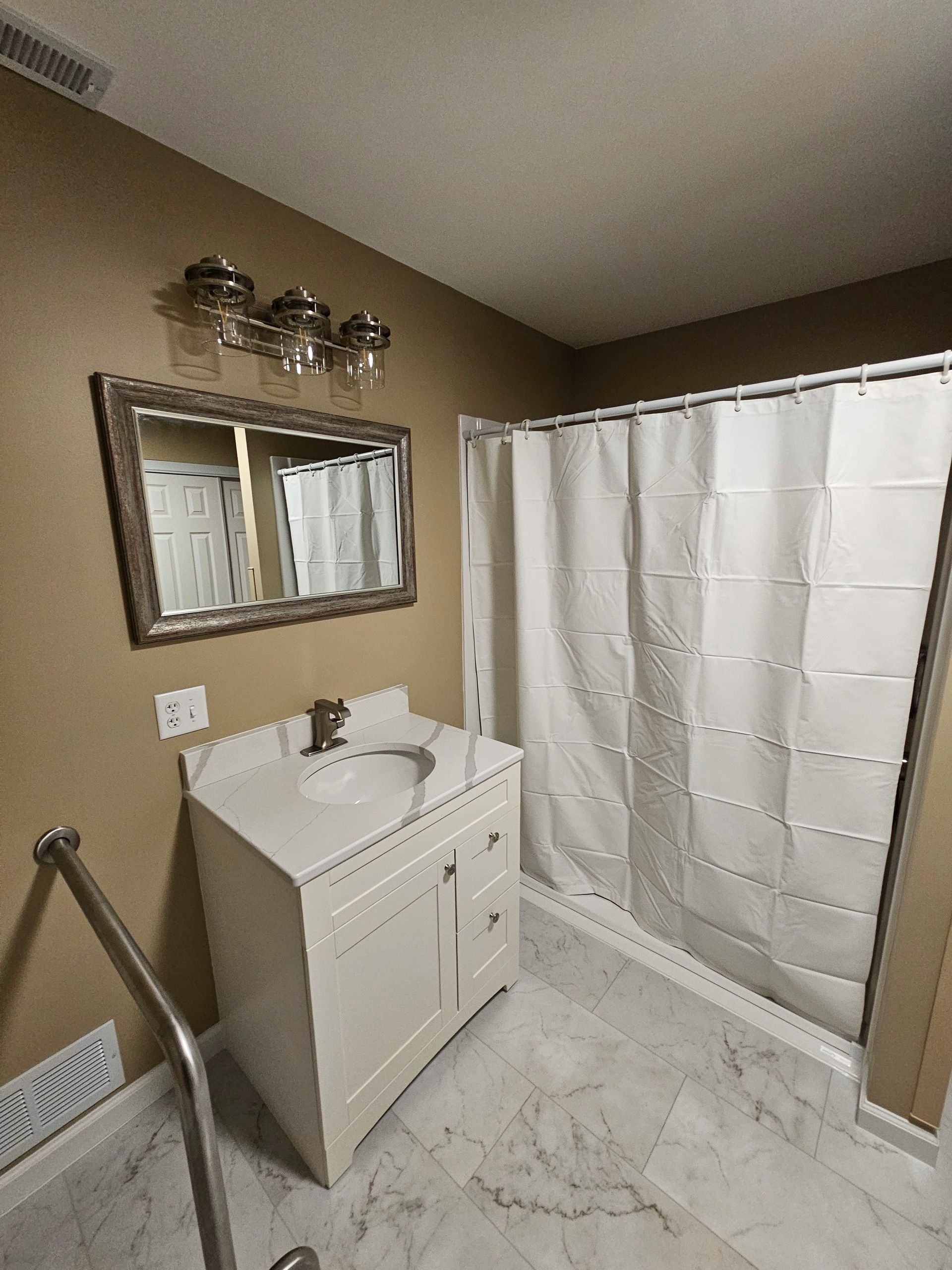 A bathroom with a sink , mirror and shower curtain.