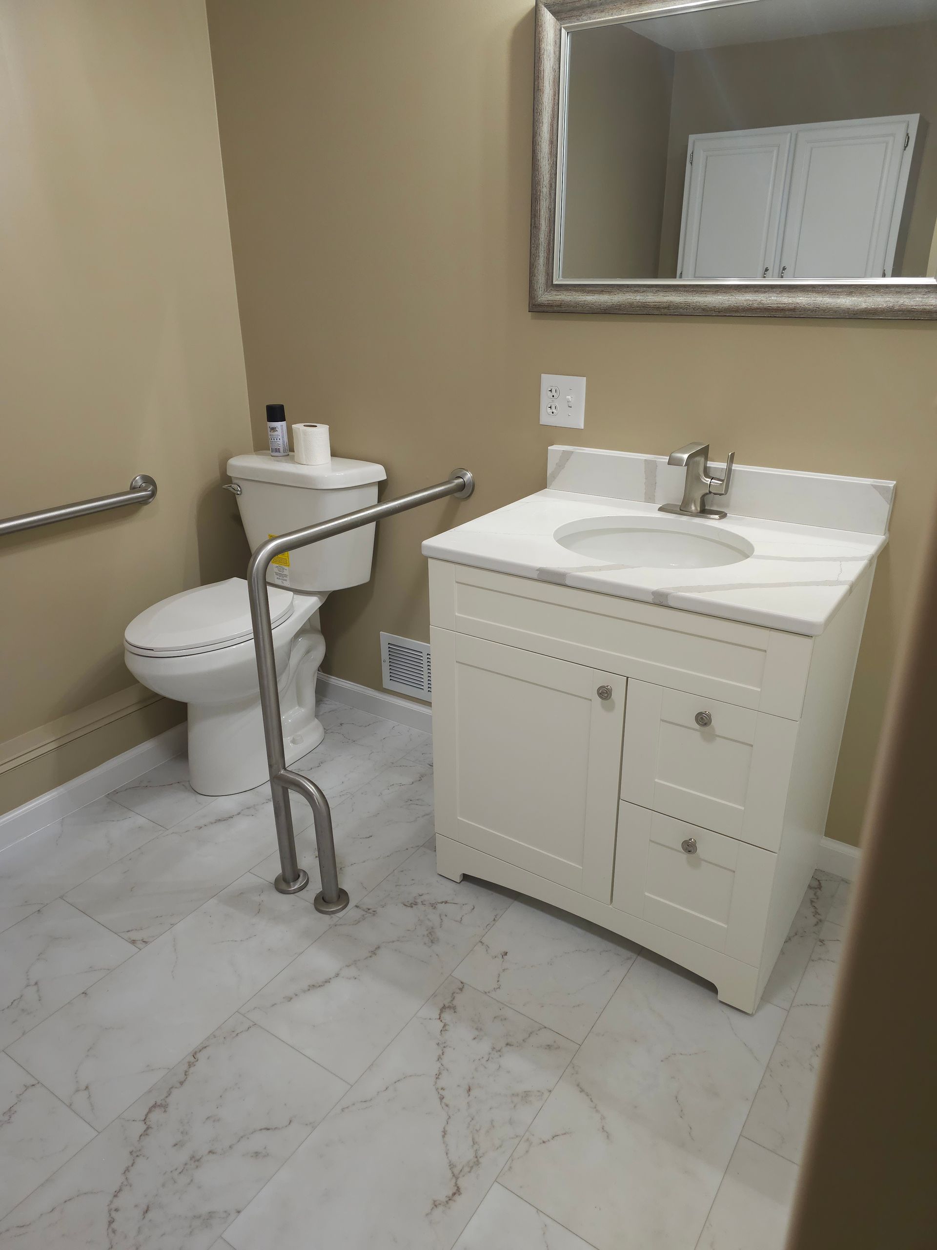 A bathroom with a toilet , sink and mirror.