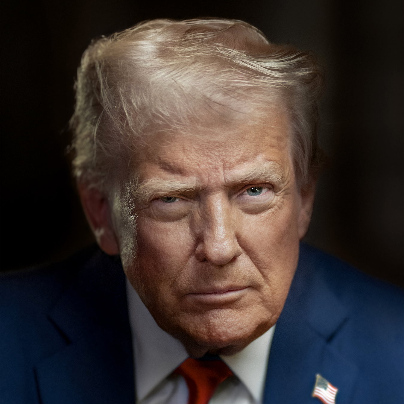 Donald Trump, in a blue suit and red tie, stares intensely at the camera.