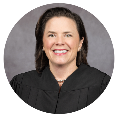 Judge in black robe, smiling.