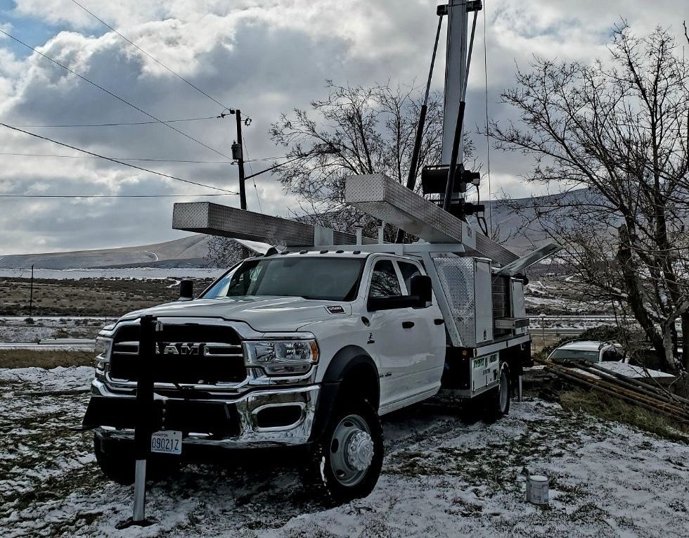 A white ram truck is parked in a snowy field.