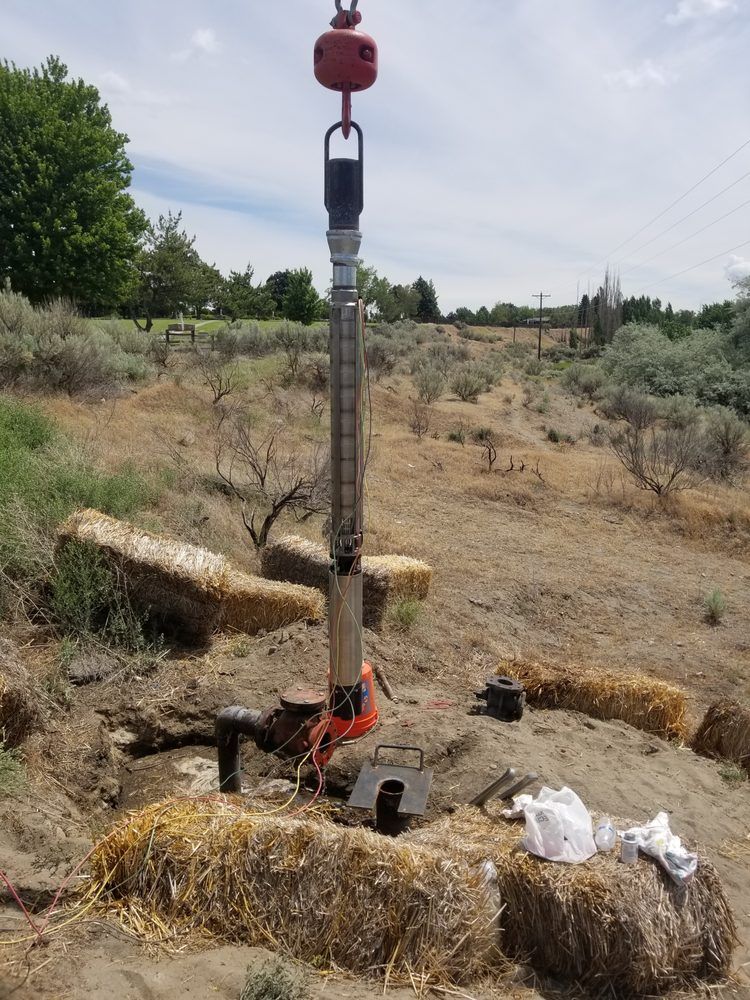 A drill is sitting on top of a pile of hay bales in the middle of a field.
