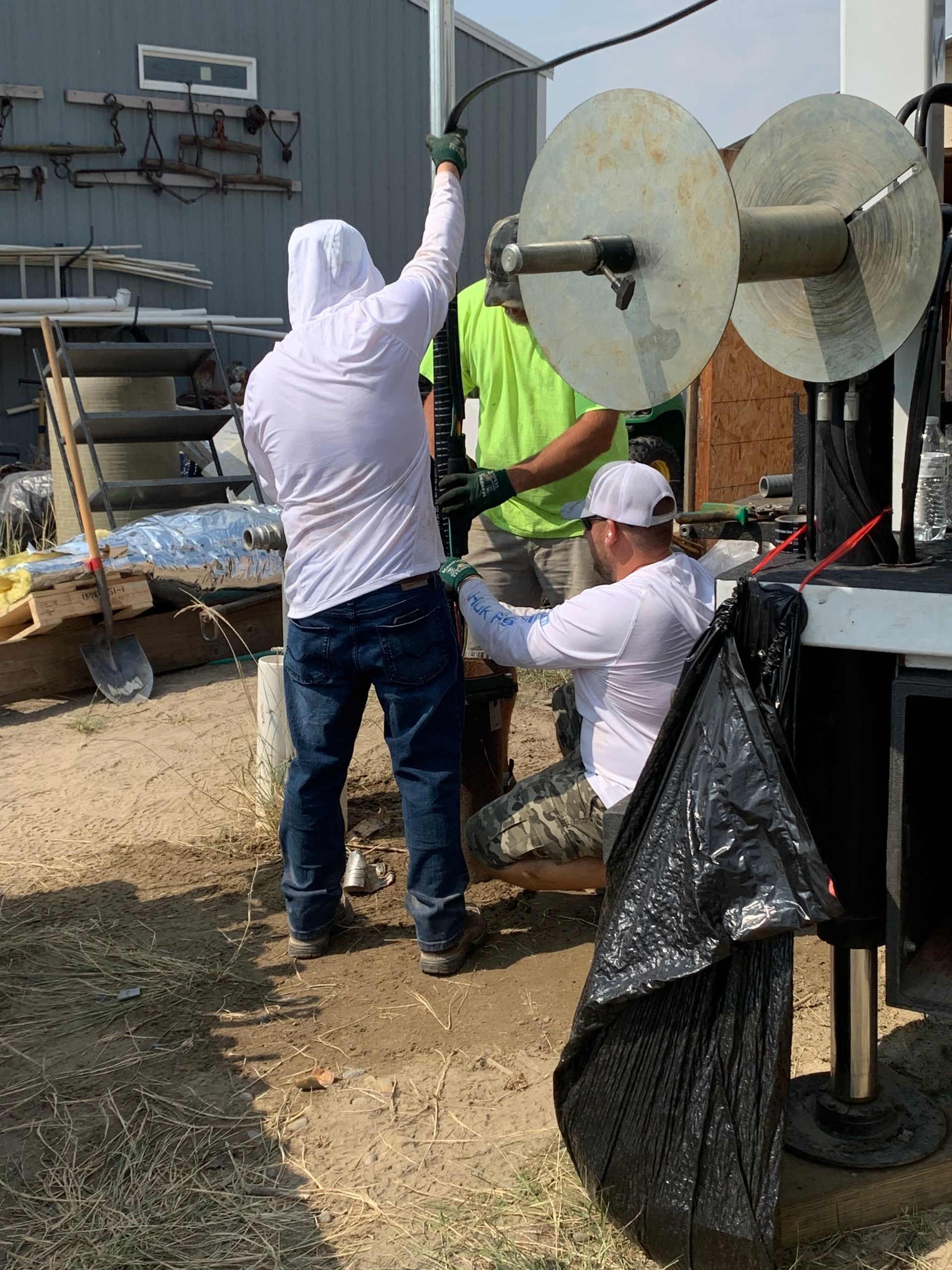 A group of men are working on a machine in a field.