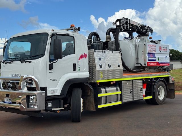A White Truck With A Yellow Tank On The Back Is Parked On A Dirt Road — Atherton Location Services In Atherton, QLD