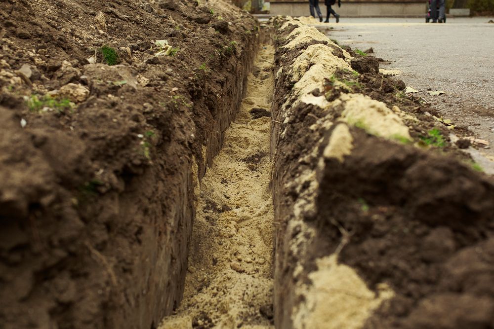 A Narrow Trench Dug in the Earth, With Piles of Dirt — Atherton Location Services In Mareeba, QLD