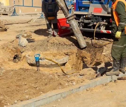 Workers Filling a Trench With Cement, Using a Hose Attached — Atherton Location Services In Atherton, QLD
