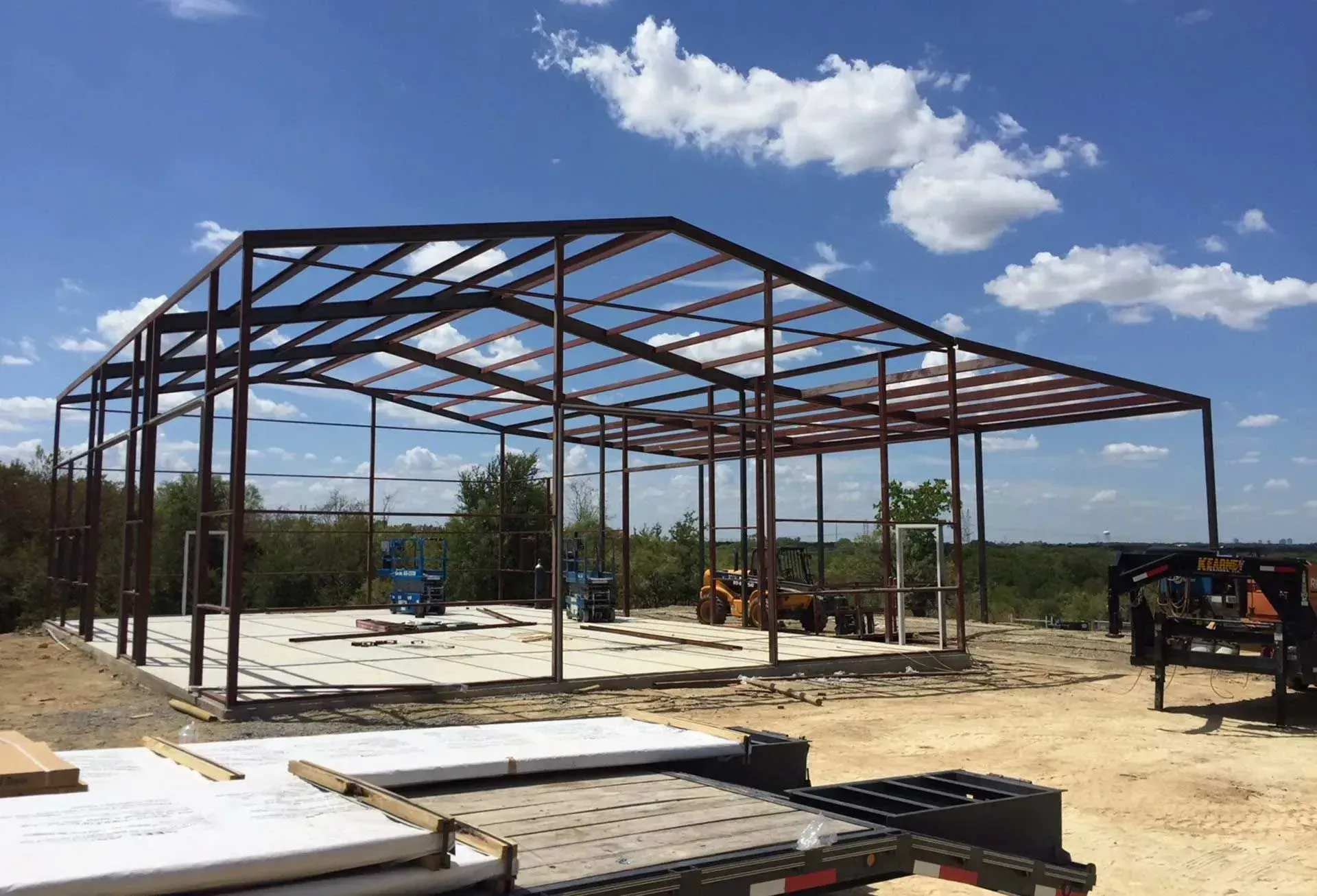 Black railing on a concrete porch with steps leading to a home's front door.
