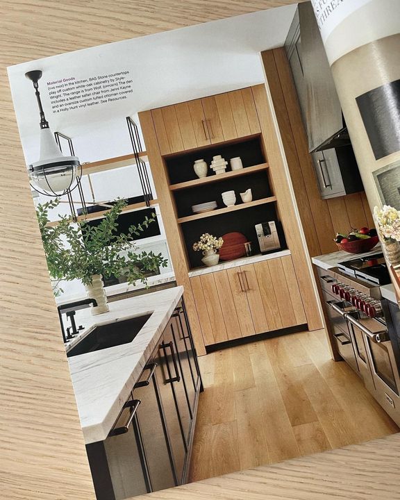 Kitchen interior with wood cabinets, light fixtures, and open shelving.