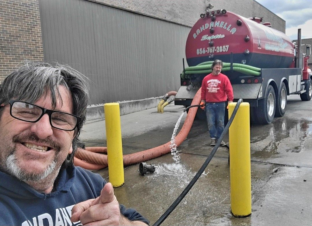 A man is pumping water into a manhole cover.
