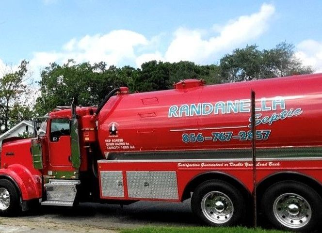 A man is fixing a drain in a bathroom with a hose.