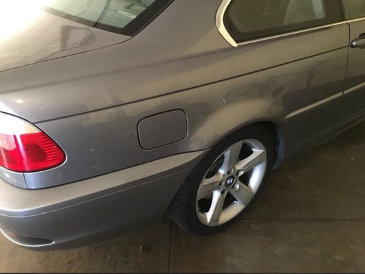 Gray BMW car's rear, showing taillight, gas door, and wheel.