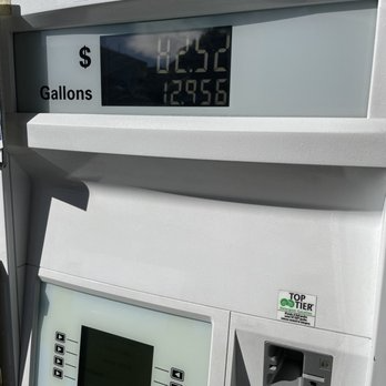 Gas pump display showing $2.52 and 12.956 gallons. White pump, outdoor setting.