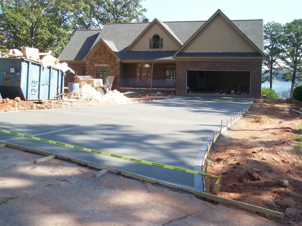 New concrete driveway in front of a house under construction; a garage is visible.