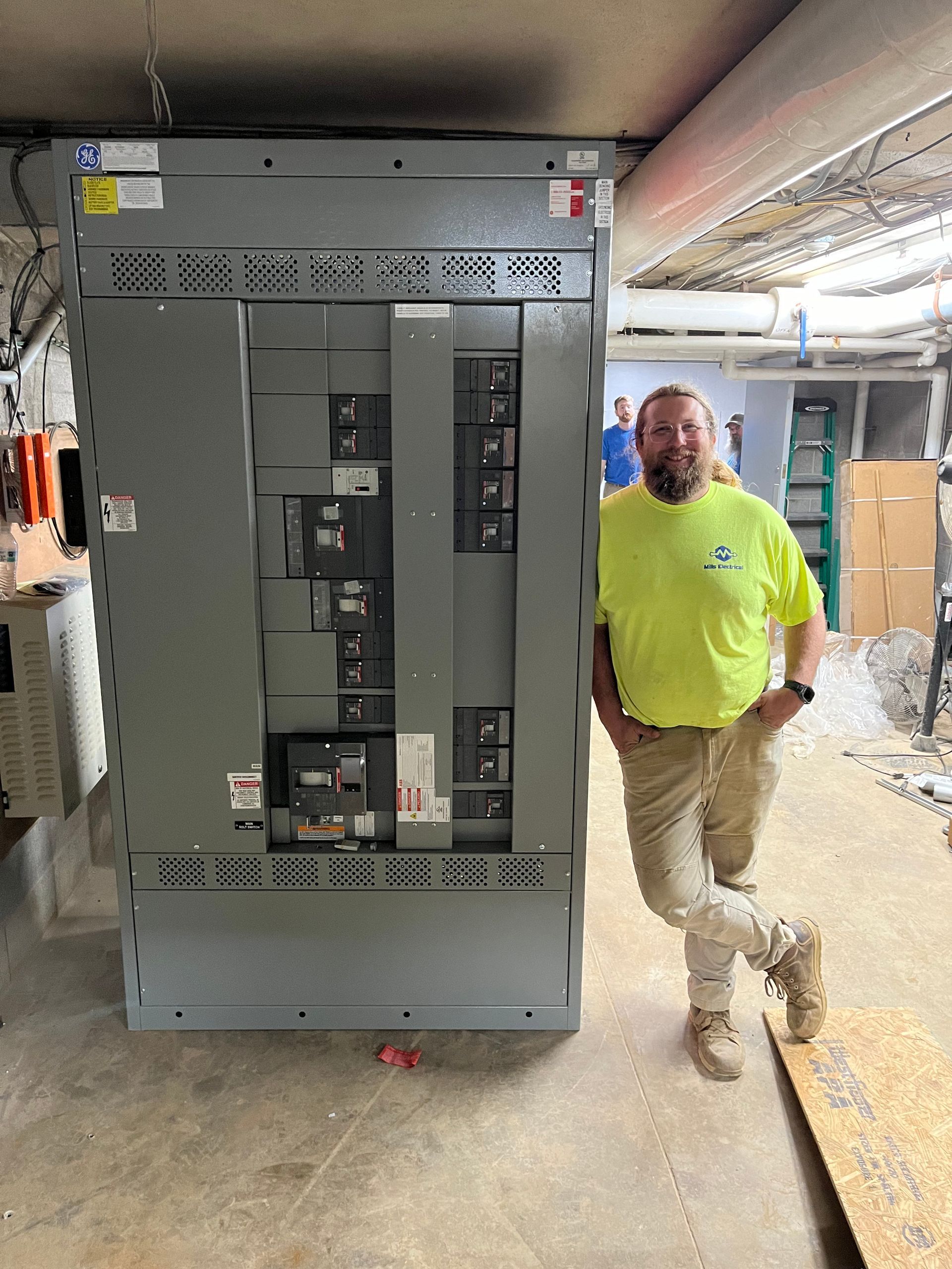 A man is standing in front of a large electrical box.