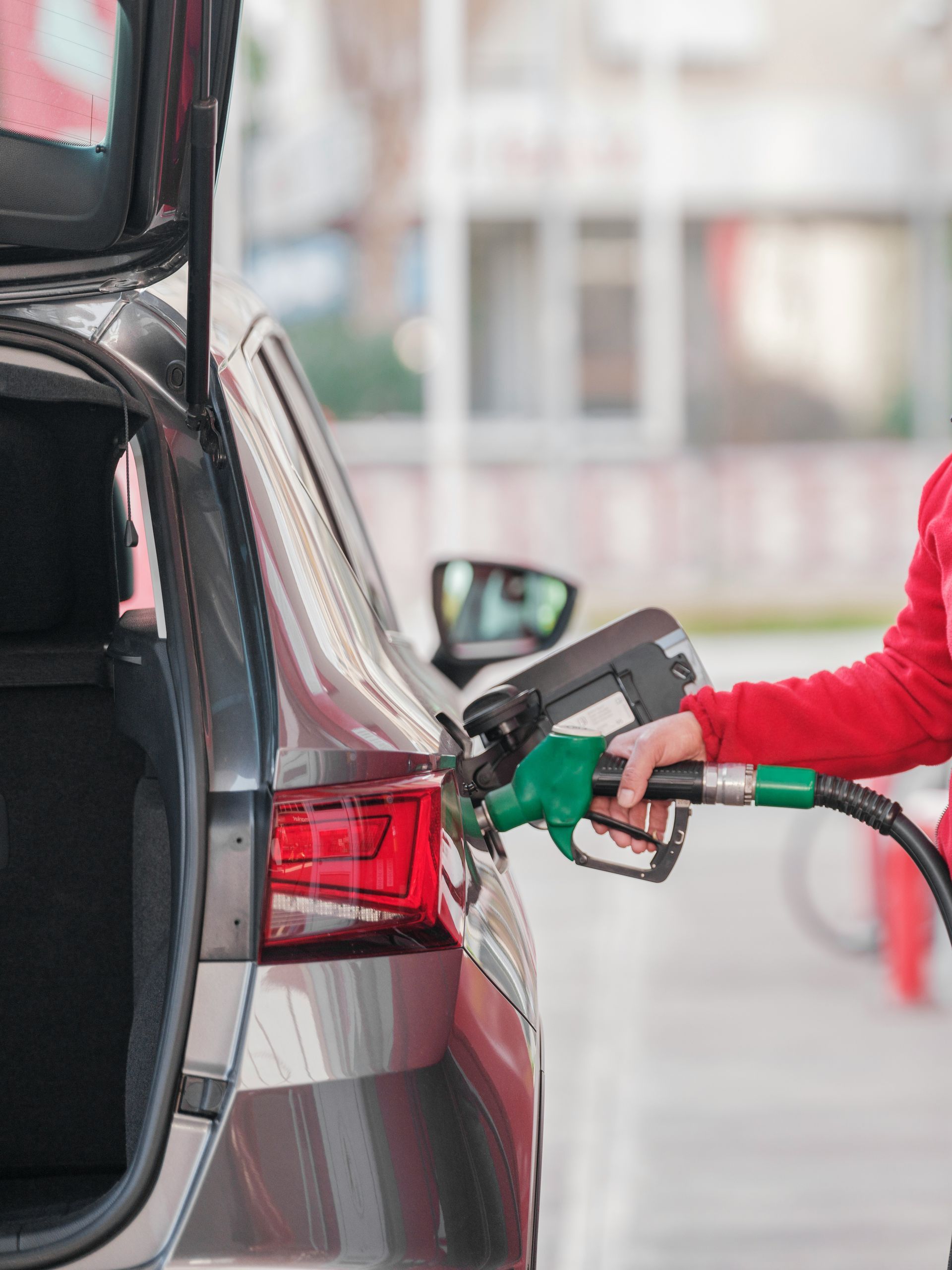 A person is pumping gas into a car at a gas station.