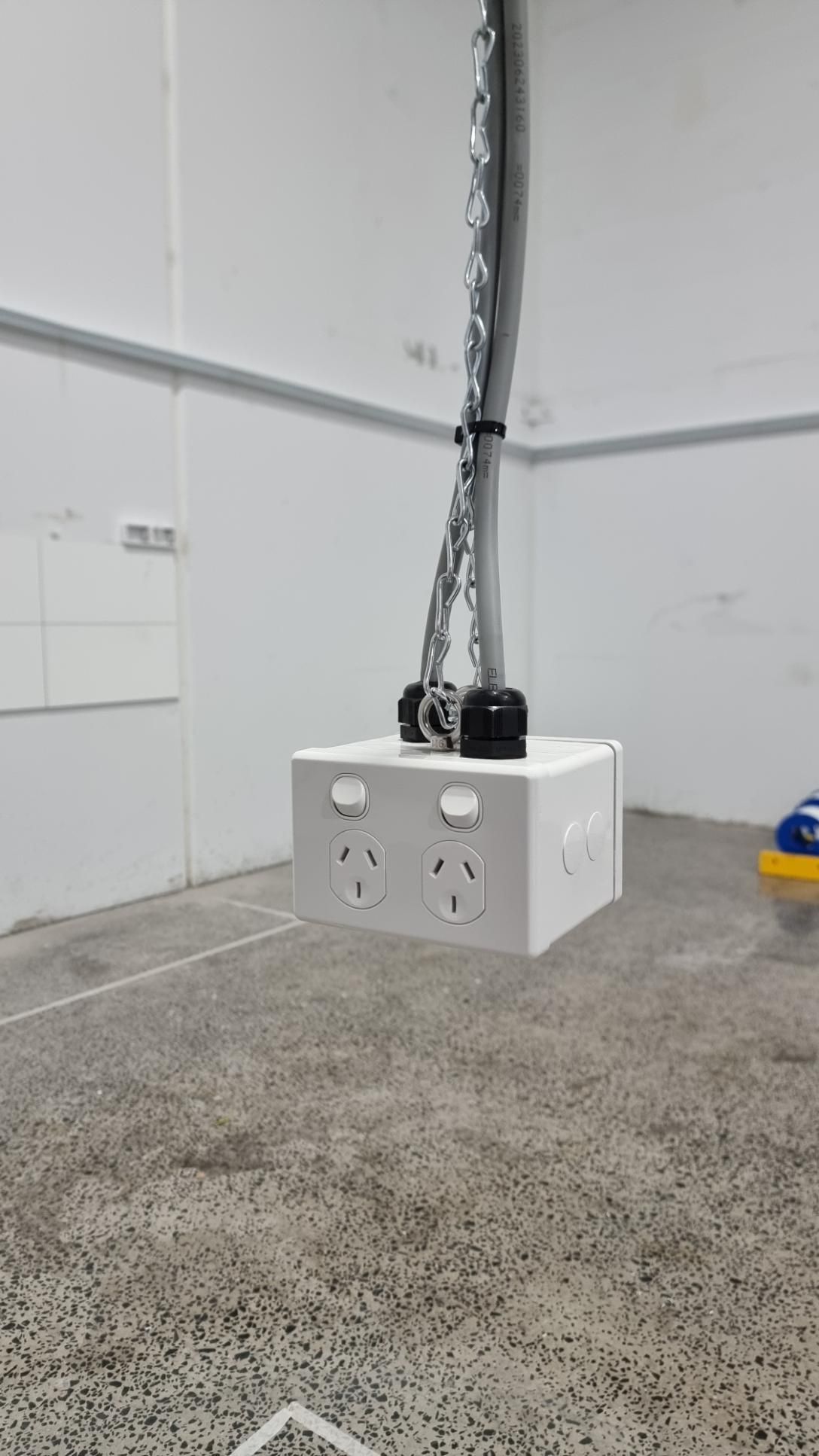 A White Box With Two Electrical Outlets Is Hanging From The Ceiling In A Room — Licence To Spark In San Remo, NSW