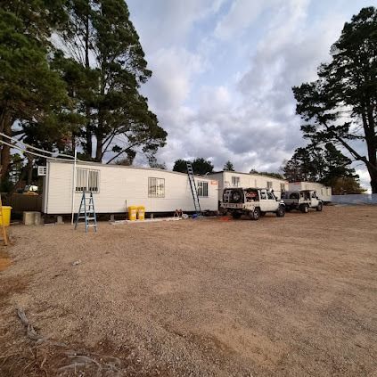A Row Of Mobile Homes Are Parked In A Dirt Lot — Licence To Spark In Bateau Bay, NSW