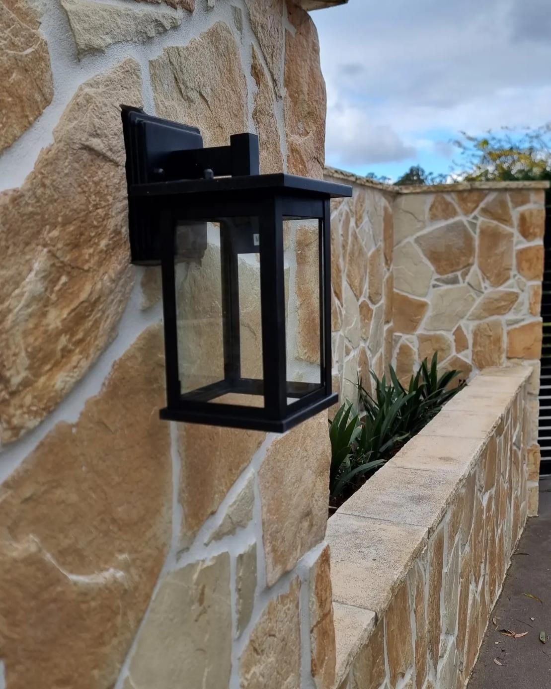 A Black Lantern Is Mounted On A Stone Wall — Licence To Spark In Wyoming, NSW