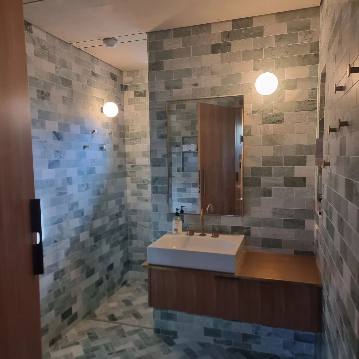 A Bathroom With Brick Walls And A Sink And Mirror — Licence To Spark In Bateau Bay, NSW