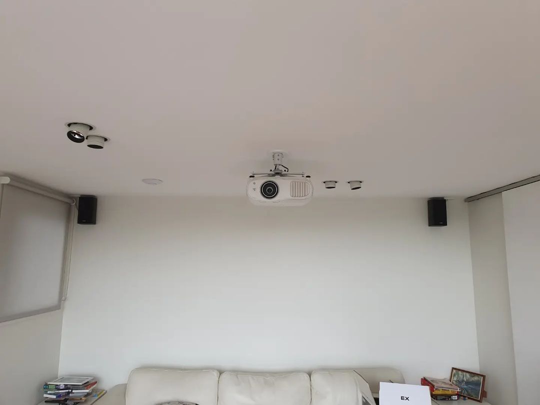 A Living Room With A Projector On The Ceiling And A Couch — Licence To Spark In Bateau Bay, NSW