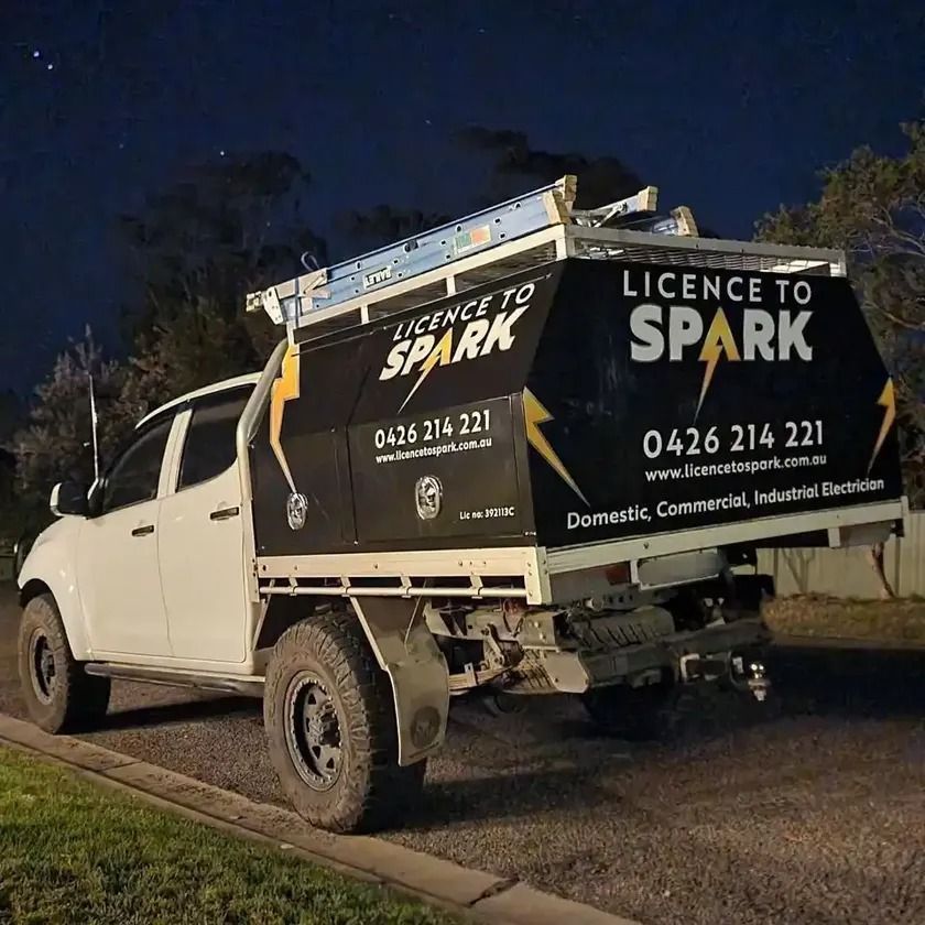 A White Truck Is Parked On The Side Of The Road At Night — Licence To Spark In Bateau Bay, NSW