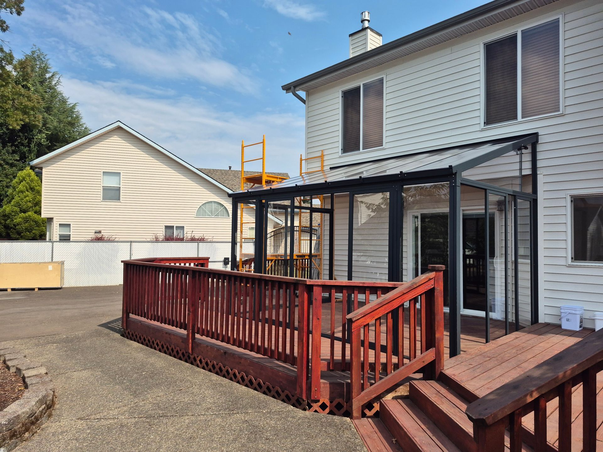 Person uses a nail gun to fasten wood planks on a deck, outdoors.