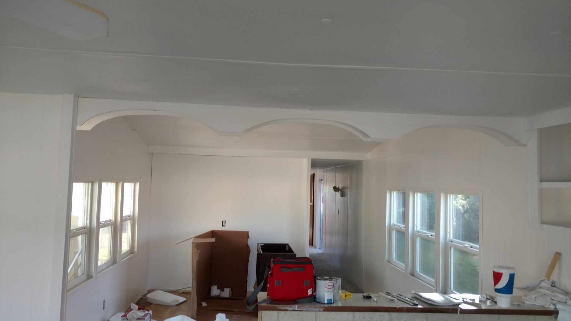 Two construction workers in hard hats silhouetted against a golden sunset, reviewing blueprints on a job site.