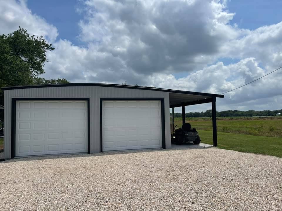 Two-car garage with attached carport; white doors, gray walls, gravel driveway, and a riding mower.