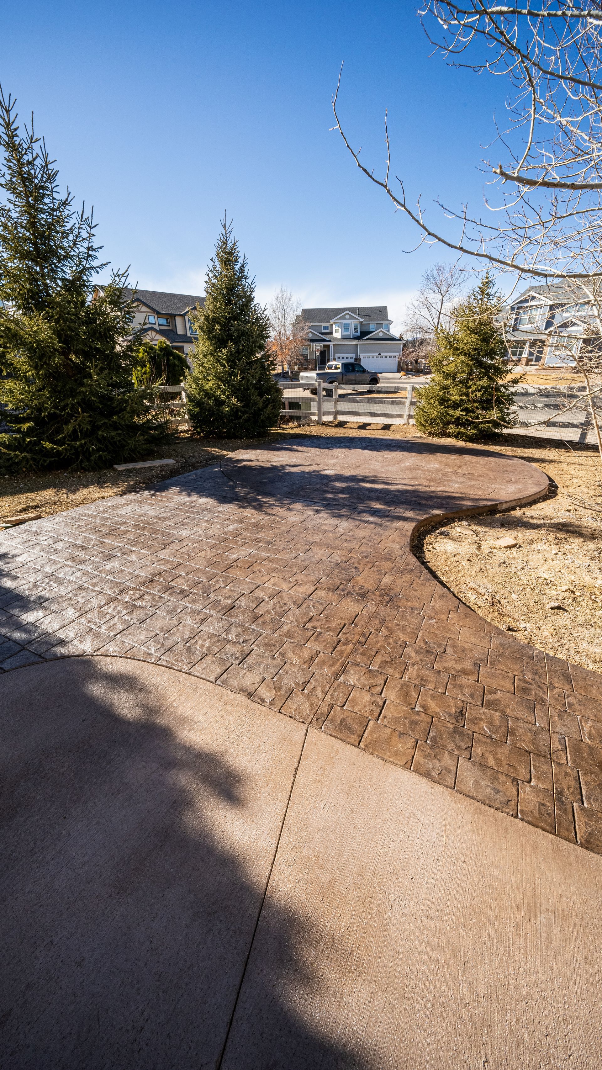 Worker smoothing wet concrete on a curb with a trowel, outdoors.