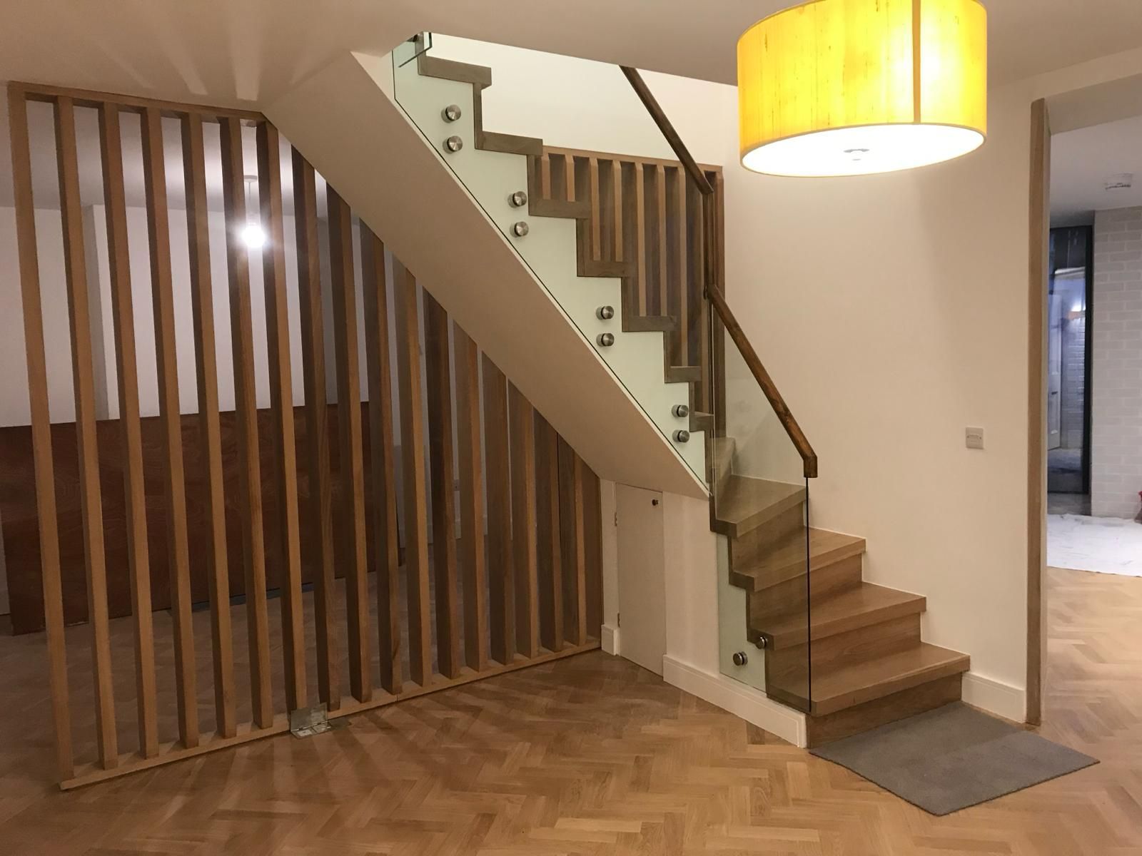 a wooden staircase with a glass railing in a living room .