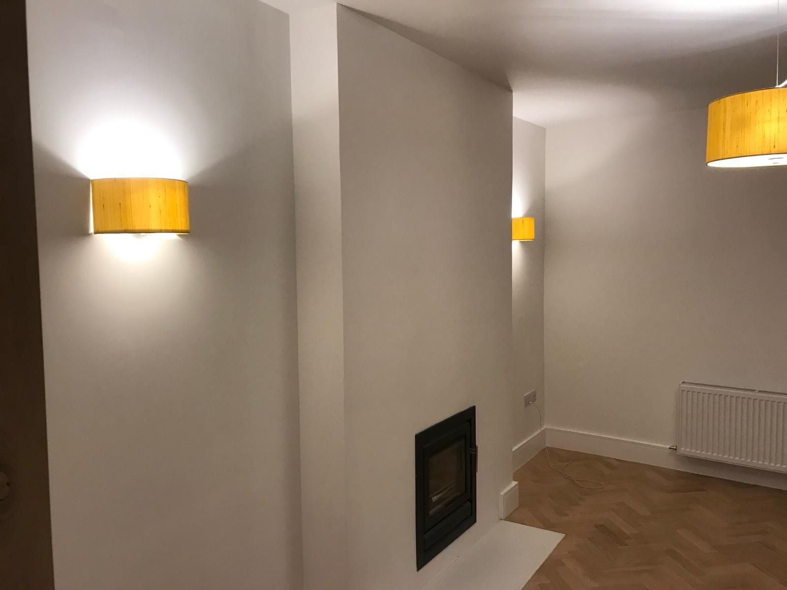 a room with a fireplace and two lights on the wall