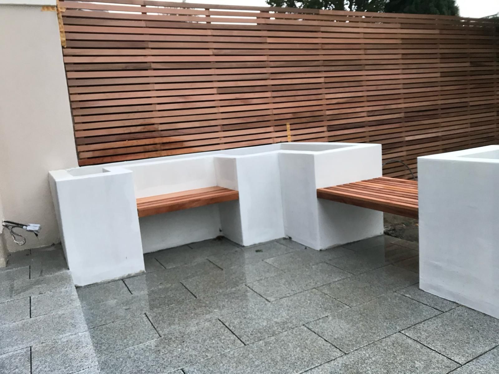 a patio with a wooden fence and a wooden bench .
