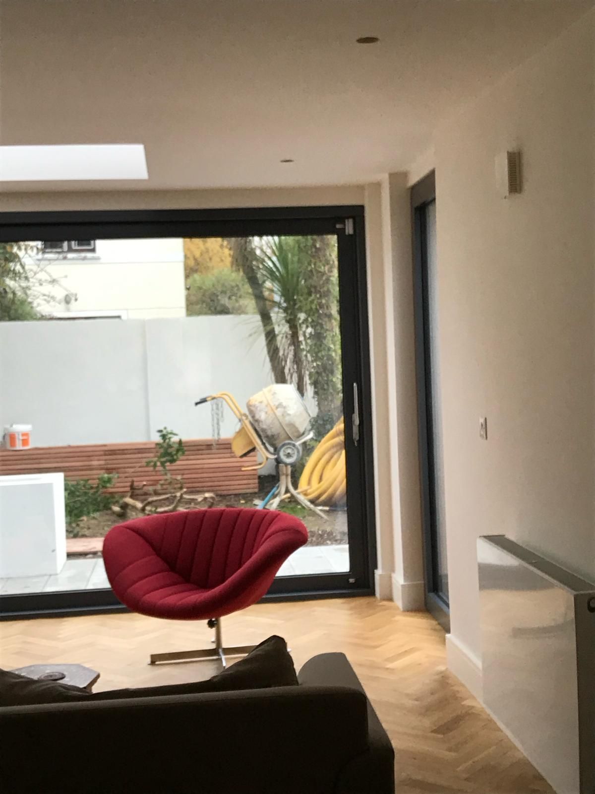 a living room with a red chair and a sliding glass door