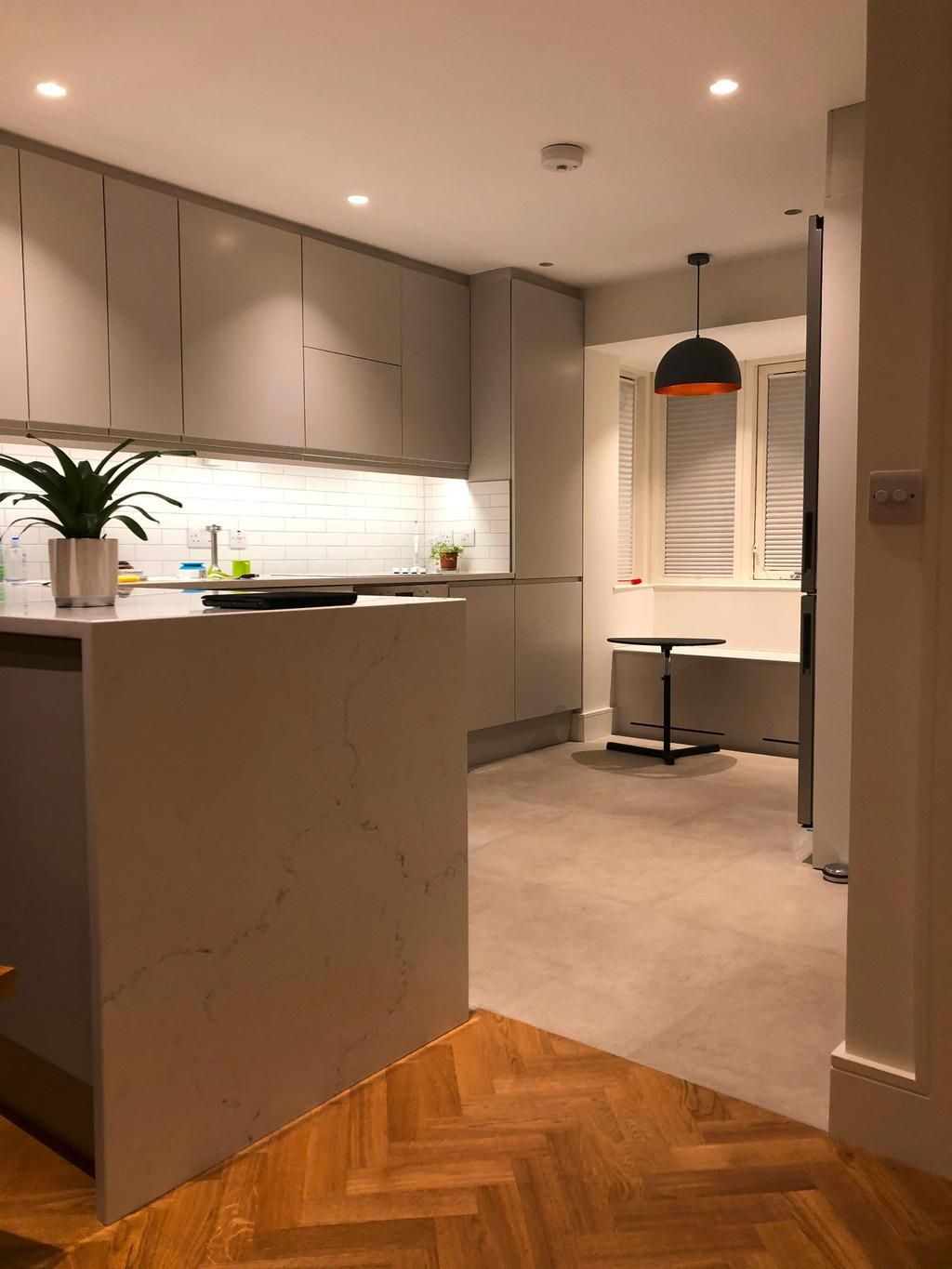 a kitchen with white cabinets and a wooden floor .
