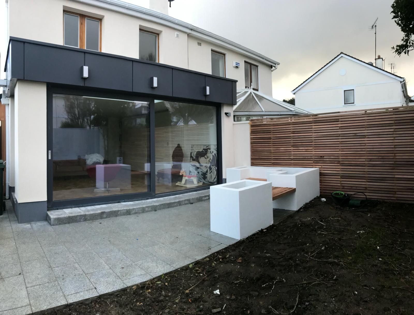 the backyard of a house with a bench and a fence