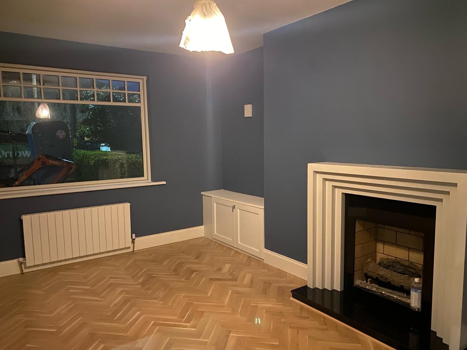 an empty living room with a fireplace and a window .