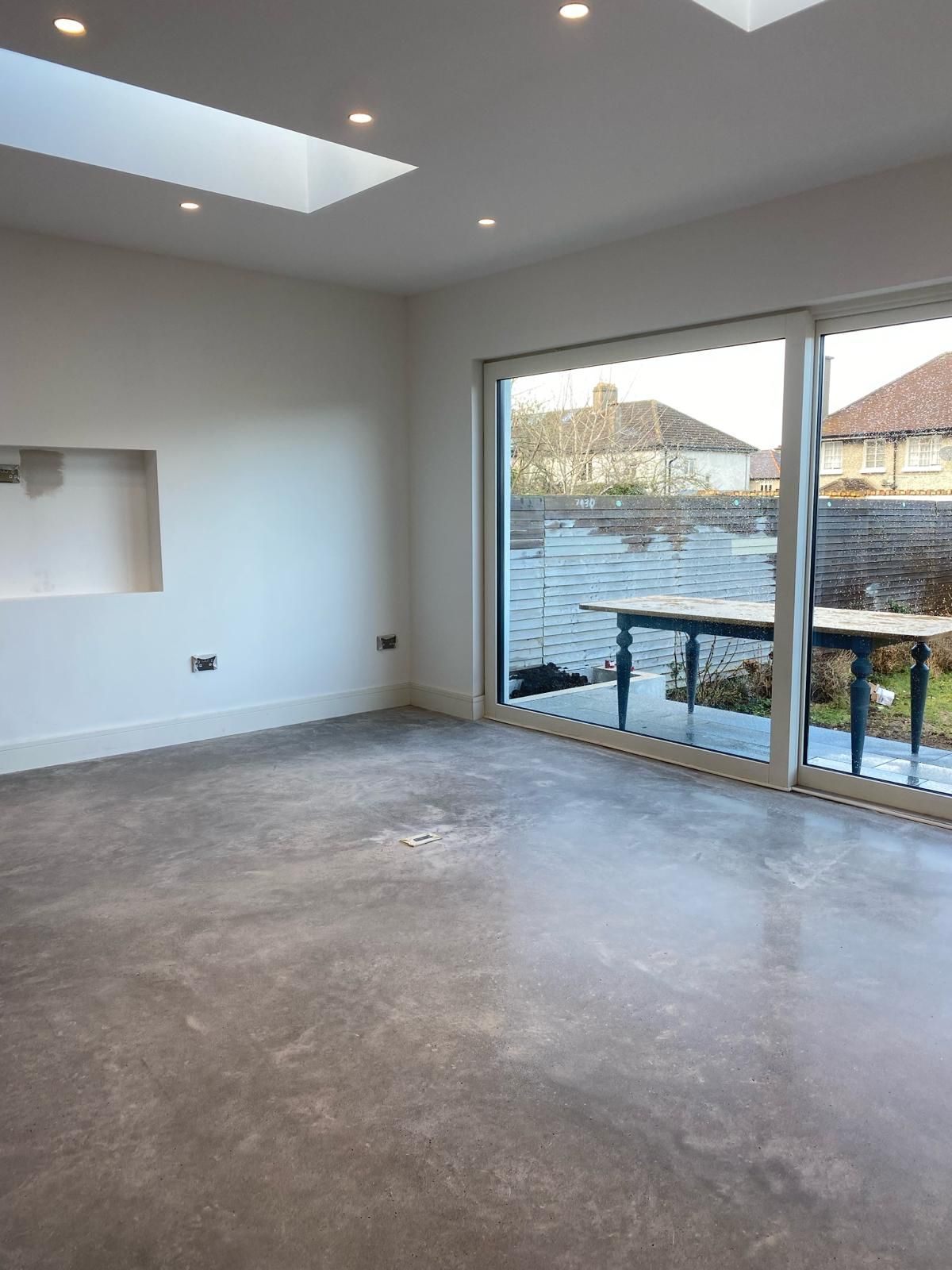 an empty living room with a sliding glass door and a skylight .