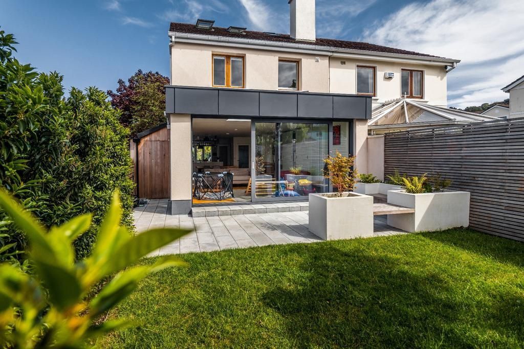 a house with a large lawn and a patio in front of it .