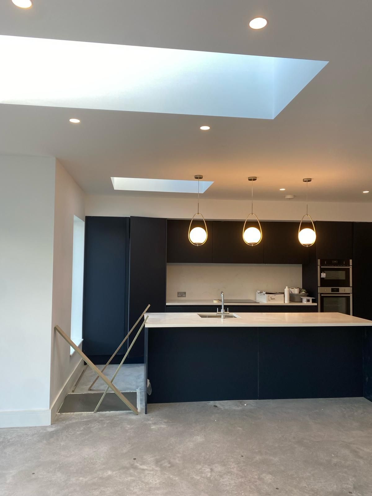 a kitchen with a large island and stairs leading to it