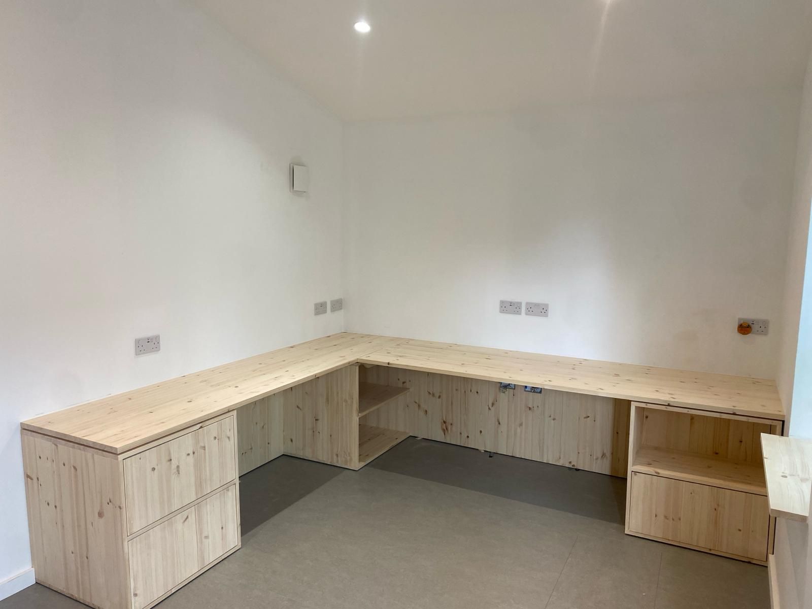 there is a wooden desk in the middle of the room .