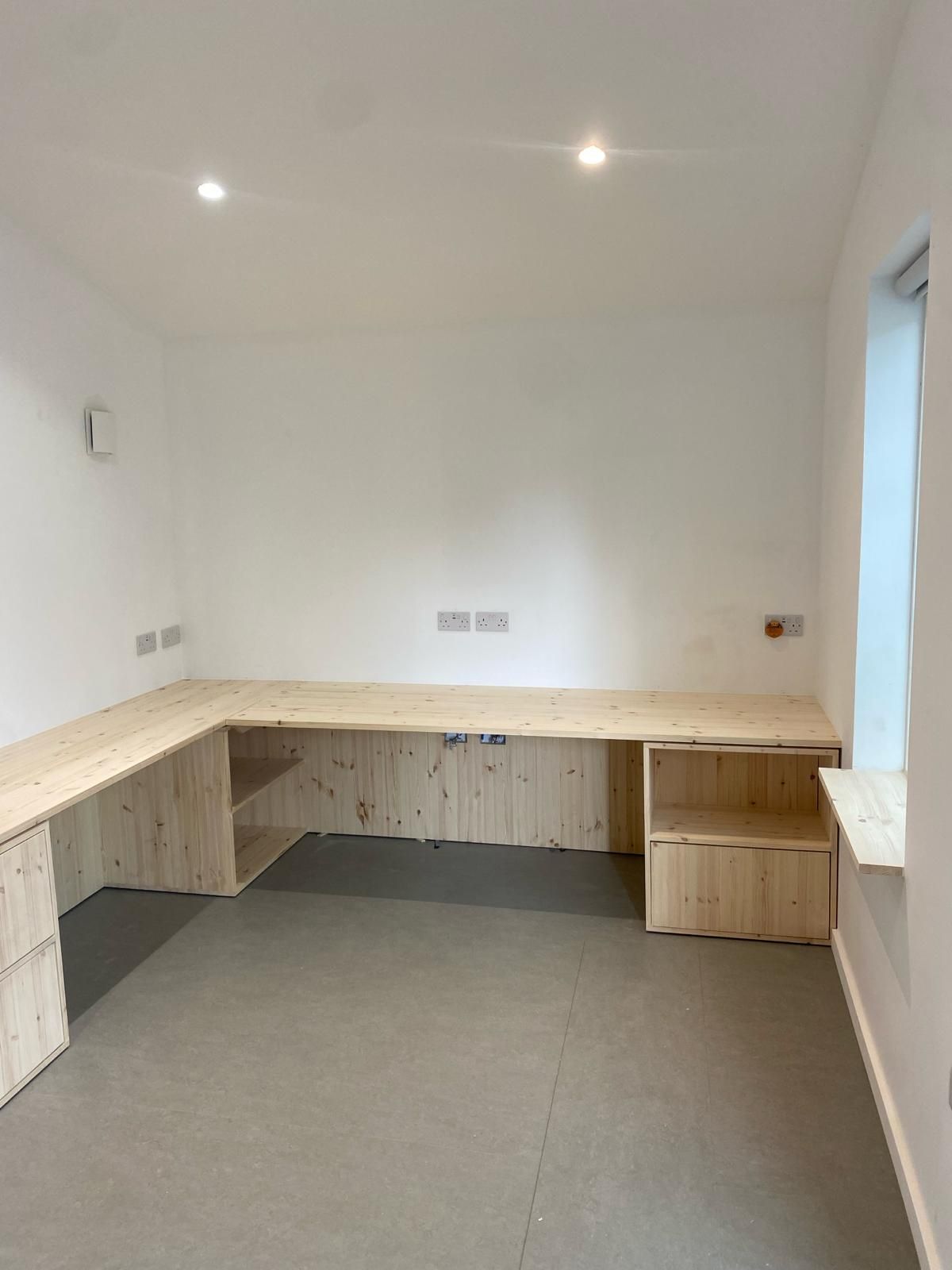 there is a wooden desk in the middle of the room .