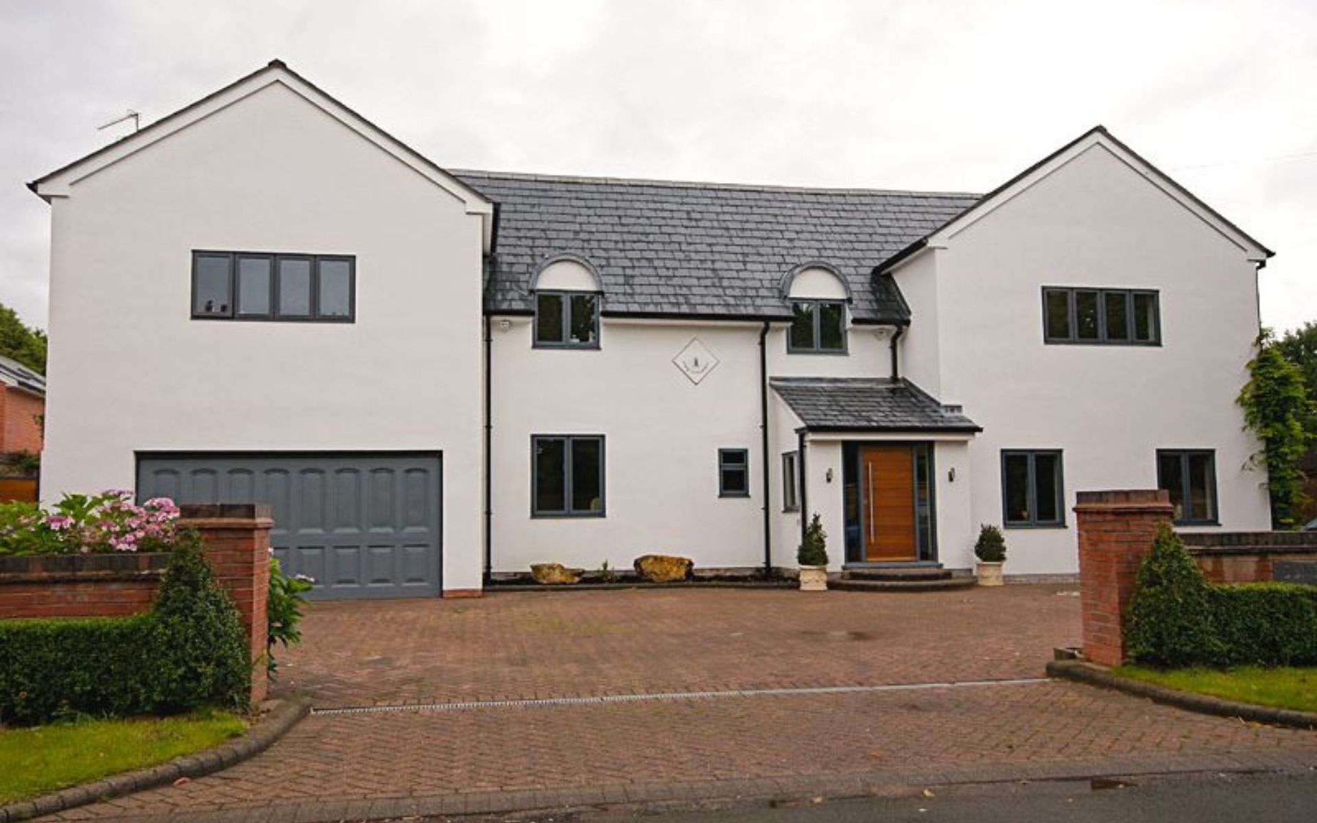 a large white house with a brick driveway in front of it