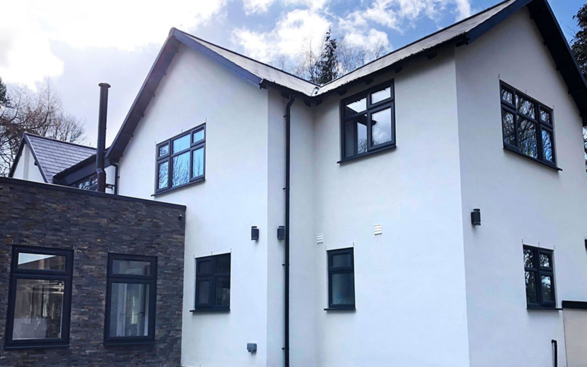 a large white house with black windows and a black roof .
