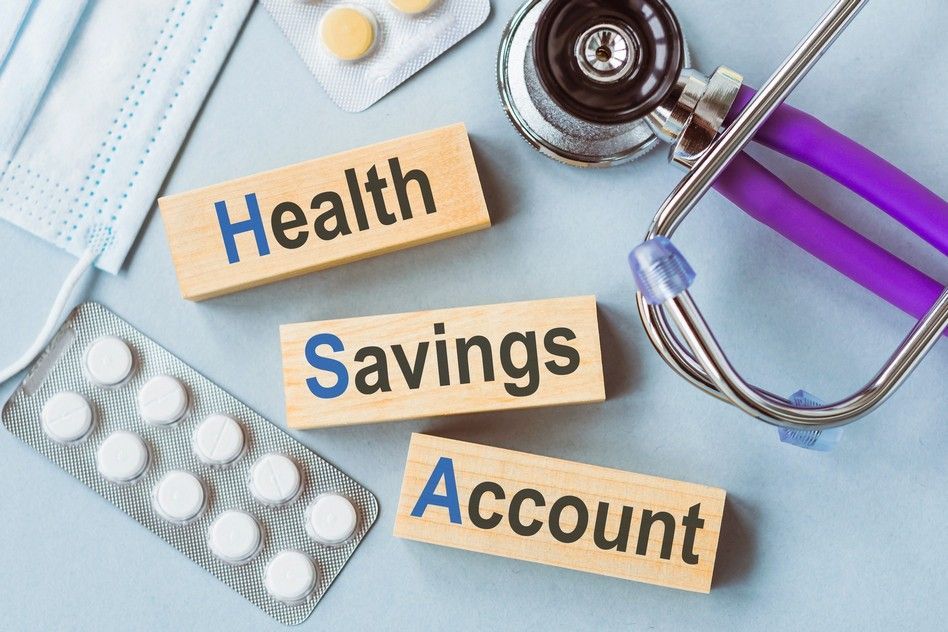 A stethoscope , pills , a mask and wooden blocks with the words health savings account written on them.