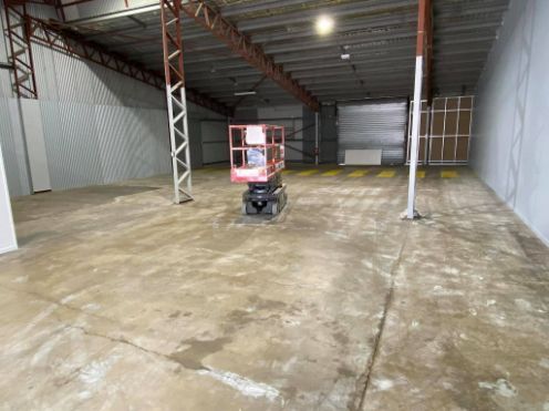 An Empty Warehouse With A Lift In The Middle Of It — Tailored Services in Mackay Harbour, QLD