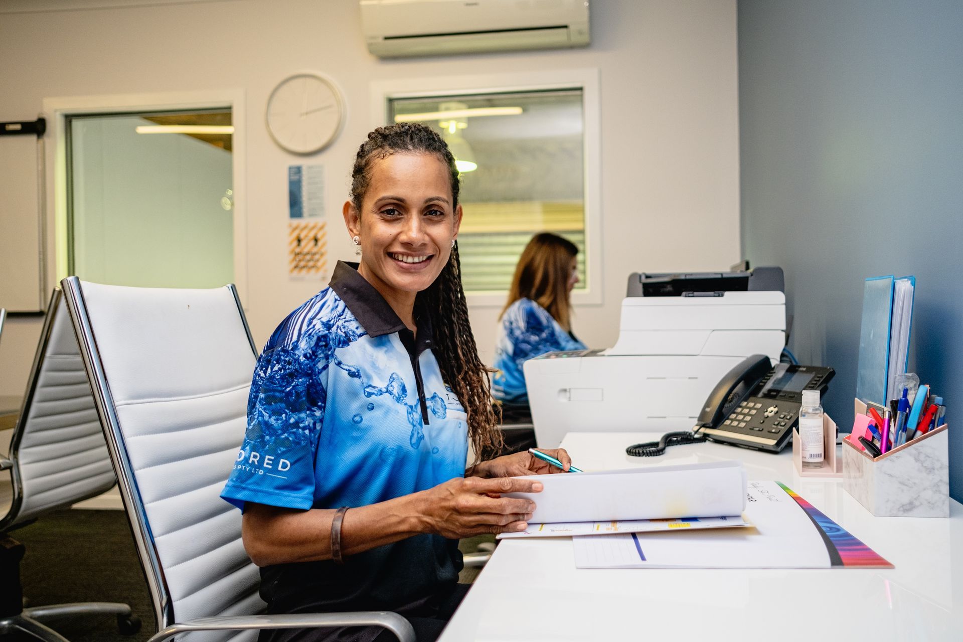 A Man Is Cleaning The Floor With A Vacuum Cleaner In An Office — Tailored Services in Sarina, QLD