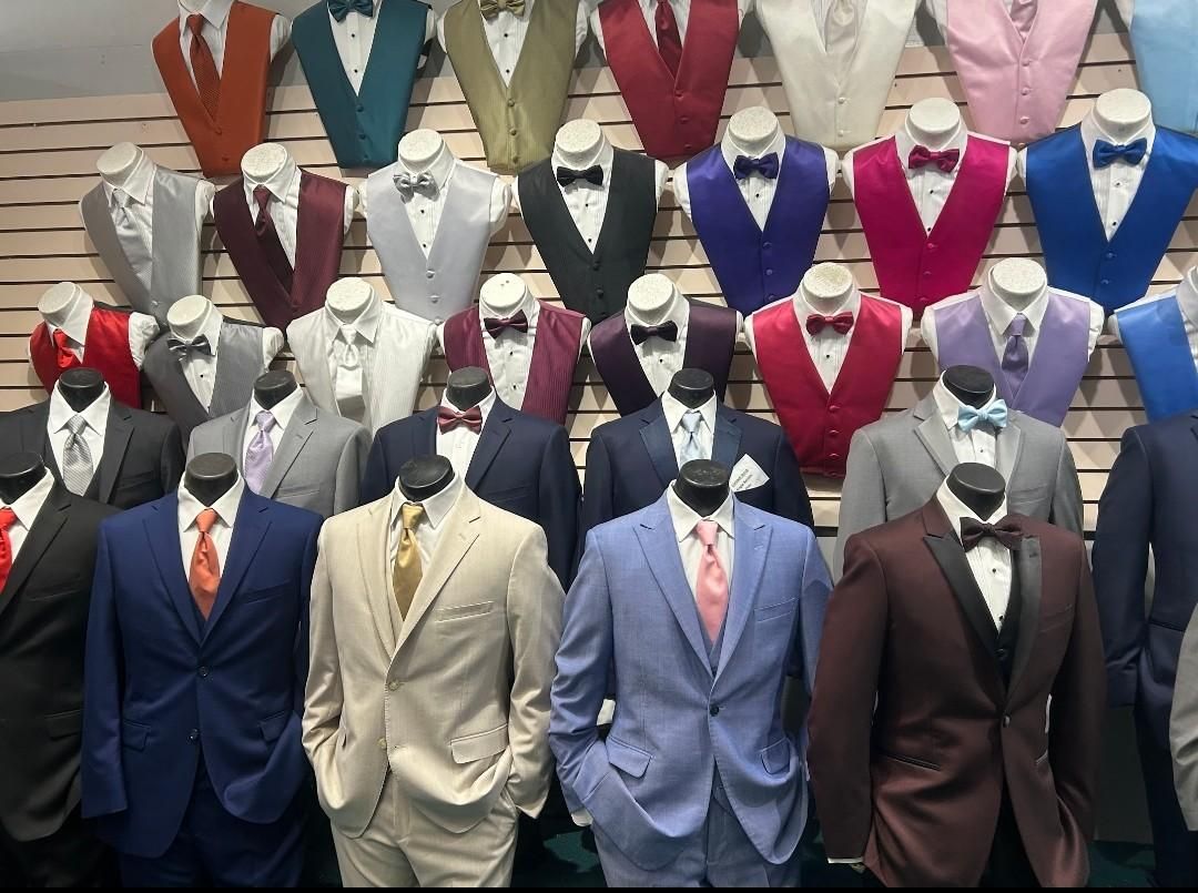 Rows of men’s suits on mannequins in various colors displayed in a store window