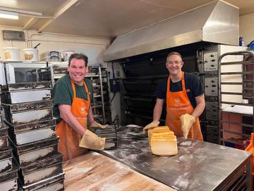 Two staff members presenting pastries